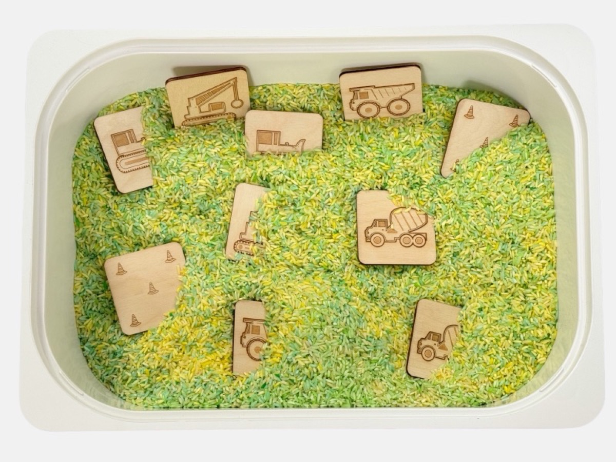 Construction vehicle memory match tiles in a green sensory bin