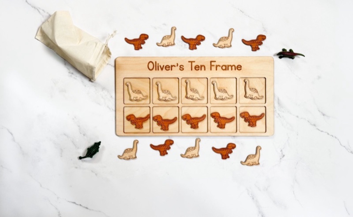 Dinosaur-themed wooden ten frame with twenty counters for Montessori math