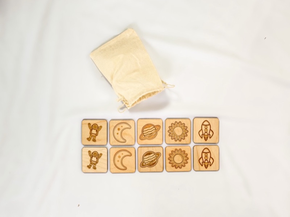 Wooden space memory match tiles laid out with a cotton muslin bag