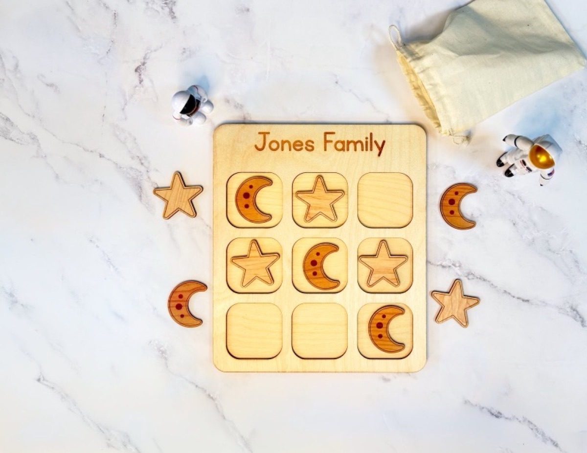 Space-themed wooden travel tic tac toe board with rocket and planet pieces